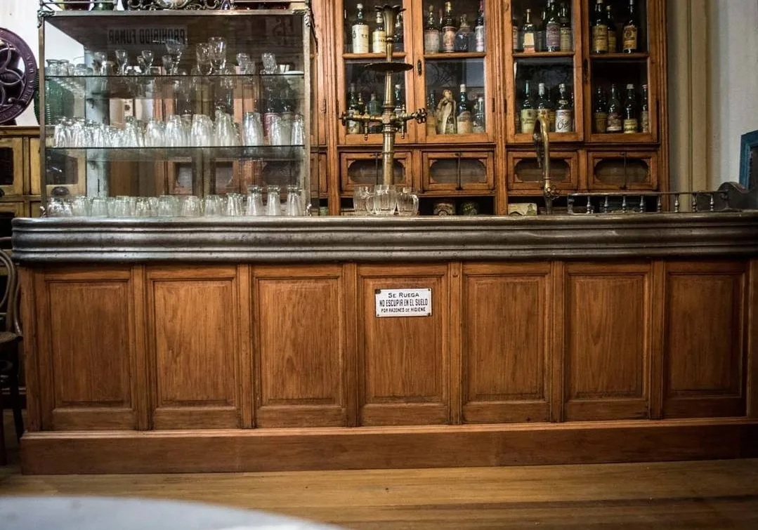 Mostrador de bar de roble con estaño y vitrinas de botellas